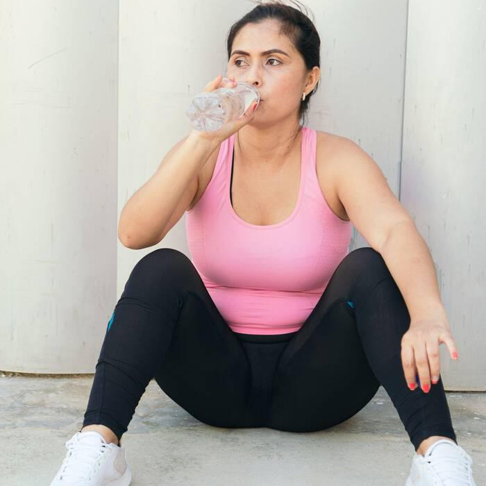 Athletic Woman Drinking Water During Workout